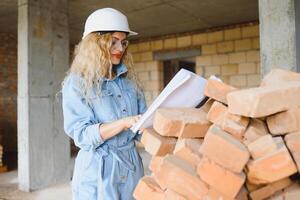 magazzino donna lavoratore. donna costruttore nel elmetto protettivo. ragazza ingegnere o architetto. casa ristrutturazione. qualità ispettore. costruzione lavoro occupazione. costruzione lavoratore. signora a costruzione luogo. foto