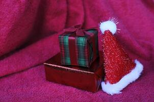 primo piano della confezione regalo e della decorazione del cappello di natale su sfondi del tappeto rosso foto