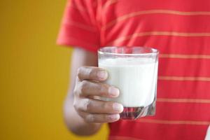 bambino ragazzo mano tenere un bicchiere di latte foto