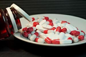 bianca e rosso pillole nel un' piatto. avvicinamento. il concetto di Salute, trattamento. foto