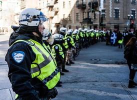 montreal, canada, 2 aprile 2015 - i poliziotti fanno una fila per controllare i manifestanti foto