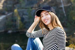 felice giovane donna in un blazer elegante in posa su uno sfondo di montagne e foreste - concetto di riposo attivo. foto