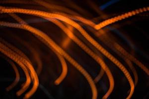 luce arancione sfocatura sentiero estate luci astratte in movimento effetto vortice sentiero nero foto