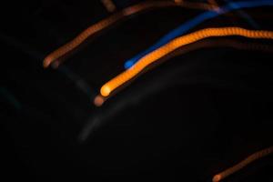 luce arancione sfocatura sentiero estate luci astratte in movimento effetto vortice sentiero nero foto