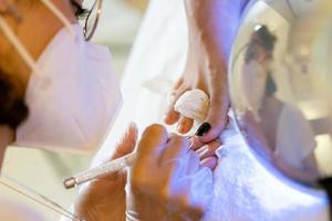 estetista che fa una pedicure dipingendo le unghie della sua cliente in un centro estetico. foto