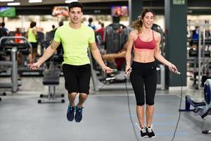 allenamento uomo e donna con salto con la corda in palestra crossfit foto