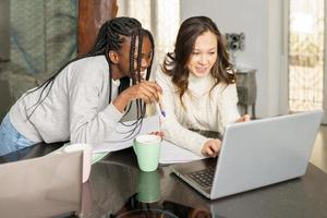 due ragazze del college che studiano insieme a casa con i laptop mentre bevono caffè foto
