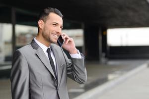 attraente giovane imprenditore al telefono in un edificio per uffici foto