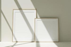 set di cornici per foto in legno mockup sul pavimento appoggiate al muro della stanza con ombra