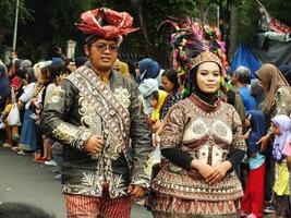 surakarta città, centrale Giava, Indonesia, Maggio 15, 2024. turista attrazione su un' tradizionale costume parata a schiaffo riyadi strada. foto