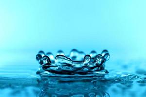 superficie dell'onda di acqua trasparente blu chiaro con bolla di spruzzi sul blu. foto