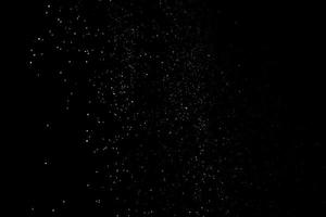 le particelle bianche su sfondo nero che rappresentano una nevicata. riprese in sovrapposizione sulla neve per dare un effetto gelido o invernale alla presentazione video. foto