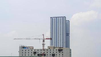 il grattacielo con accanto un edificio. edificio in costruzione con una gru opera. la vista dello sviluppo dei grattacieli della città. foto
