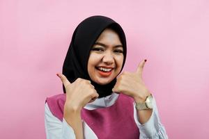 primo piano di bella giovane donna musulmana con il pollice in alto la mano, buon lavoro, vittoria, isolata foto
