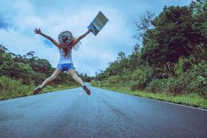 le donne asiatiche viaggiano rilassarsi durante le vacanze. saltare sulla strada foto