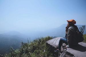 le donne asiatiche viaggiano rilassarsi durante le vacanze. sedersi e guardare il paesaggio sulla montagna. parco di montagna felicemente. in Thailandia foto