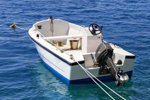 una barca a motore è ancorata nelle limpide acque del mar Ionio. foto