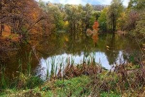 paesaggio del lago di foresta autunnale con cielo blu riflesso nell'acqua. foto