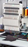 macchina da ricamo industriale con fili multicolori, primo piano, immagine verticale. foto