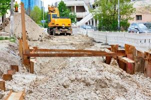 riparazione della rete di riscaldamento della città sulla carreggiata, pali metallici conficcati nel terreno sabbioso. foto