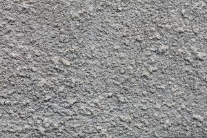 trama e sfondo di un muro grigio strutturato ricoperto da un rivestimento in cemento.