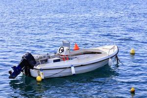 una barca a motore è ancorata nelle limpide acque del mar Ionio. foto