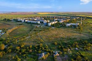 la fotografia aerea, un villaggio di lavoro tra i campi della steppa alla luce del sole al tramonto. foto