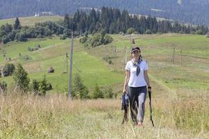 una giovane donna di umore gioioso sale su per la collina dei Carpazi. foto