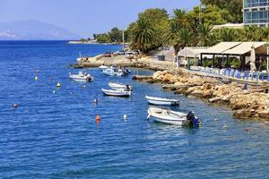 motoscafi e barche sono ancorate lungo la costa rocciosa del mar Ionio. foto