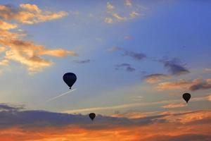 sagome di palloncini sullo sfondo del cielo mattutino con nuvole rosse infuocate. foto