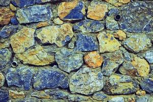 muro di pietra perfettamente organizzato, trama blu e rossa dalla trama di sfondo del muro di roccia foto