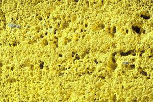 muro di pietra perfettamente organizzato, trama gialla dalla trama di sfondo del muro di roccia foto