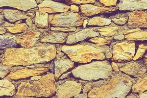 muro di pietra perfettamente organizzato, trama gialla e grigia dalla trama di sfondo del muro di roccia foto