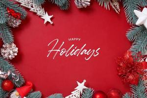 Happy Holidays testo e cornice fatta di decorazioni natalizie su sfondo rosso formato verticale foto