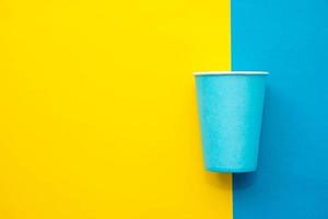 tazza di carta blu usa e getta sfondo giallo e blu foto