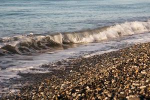 onde sulla riva del mare. increspatura dell'acqua vicino alla costa foto