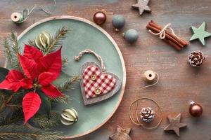 piatto con ramoscelli di abete, luci e decorazioni natalizie su sfondo scuro, spazio testo foto