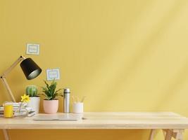 stanza di lavoro con laptop e attrezzatura da lavoro accanto al muro giallo. foto