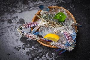 granchio di frutti di mare su ghiaccio - crudo fresco granchio nuotatore blu oceano gourmet con ghiaccio su sfondo scuro nel ristorante foto