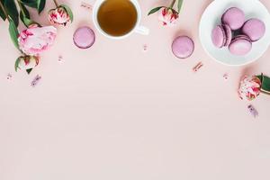 vista dall'alto di amaretti con una tazza di tè e peonie. foto