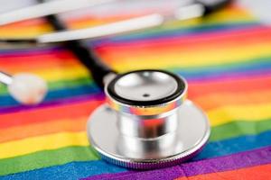 stetoscopio rosso su sfondo bandiera arcobaleno, simbolo del mese dell'orgoglio lgbt celebra annuale a giugno sociale, simbolo di gay, lesbiche, bisessuali, transgender, diritti umani e pace. foto