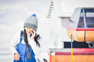 giovane istruttore di guida femminile su telefonata nella località di villeggiatura sciistica all'aperto foto