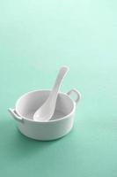 cucchiaio di ceramica in tazza su sfondo pastello foto