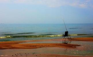 una sedia da pesca solitaria sulla riva a fine estate