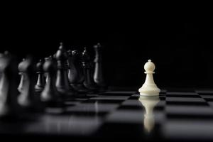 singola battaglia di scacchi bianca con molti pezzi neri a bordo, gioco di ruolo tattica e progettuale del concetto di business