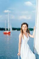 giovane ragazza sul ponte di uno yacht a vela in legno foto