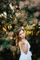 ragazza felice in un abito lungo turchese in un parco verde foto