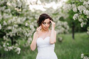 sposa in abito bianco con un grande bouquet primaverile foto