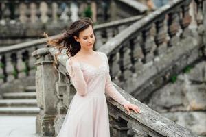 una ragazza con un vestito rosa chiaro sullo sfondo di un castello medievale foto