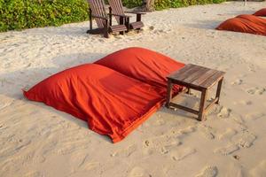 cuscino rosso e tavola apparecchiata sulla spiaggia. foto